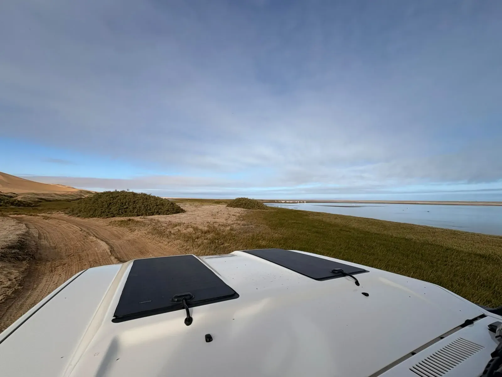 Where the dunes meet the green lagoon at Sandwich Harbour