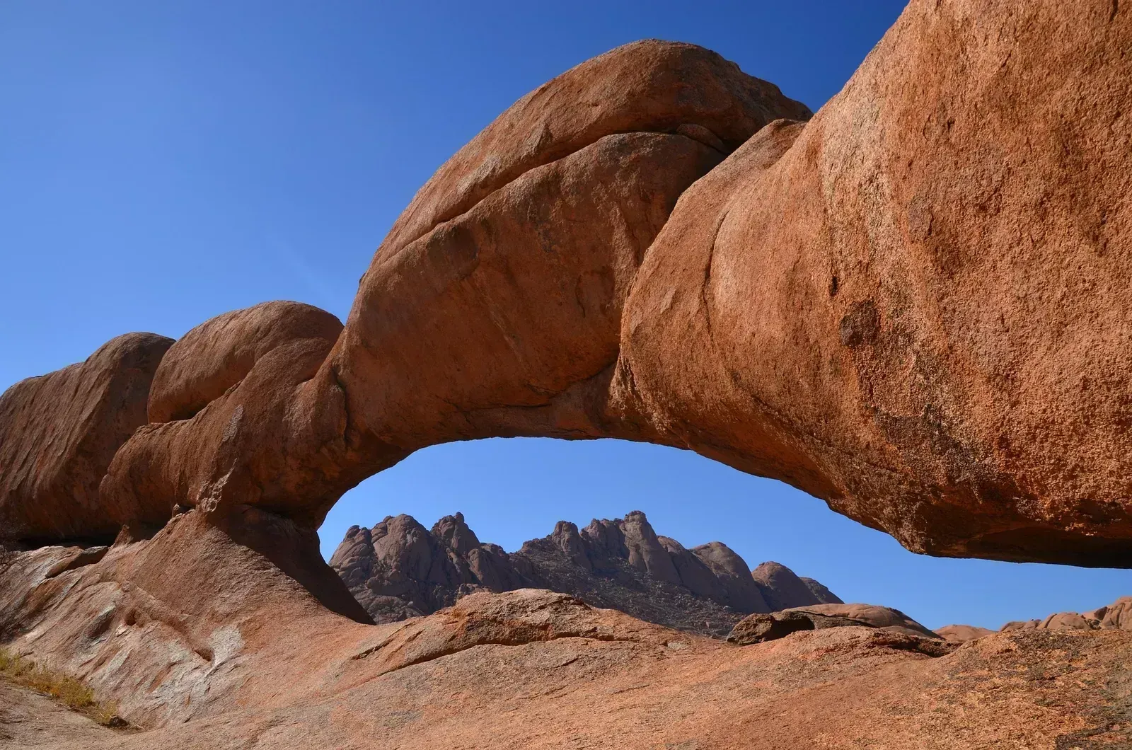 The Spitzkoppe Rock Arch frames the jagged peaks beyond