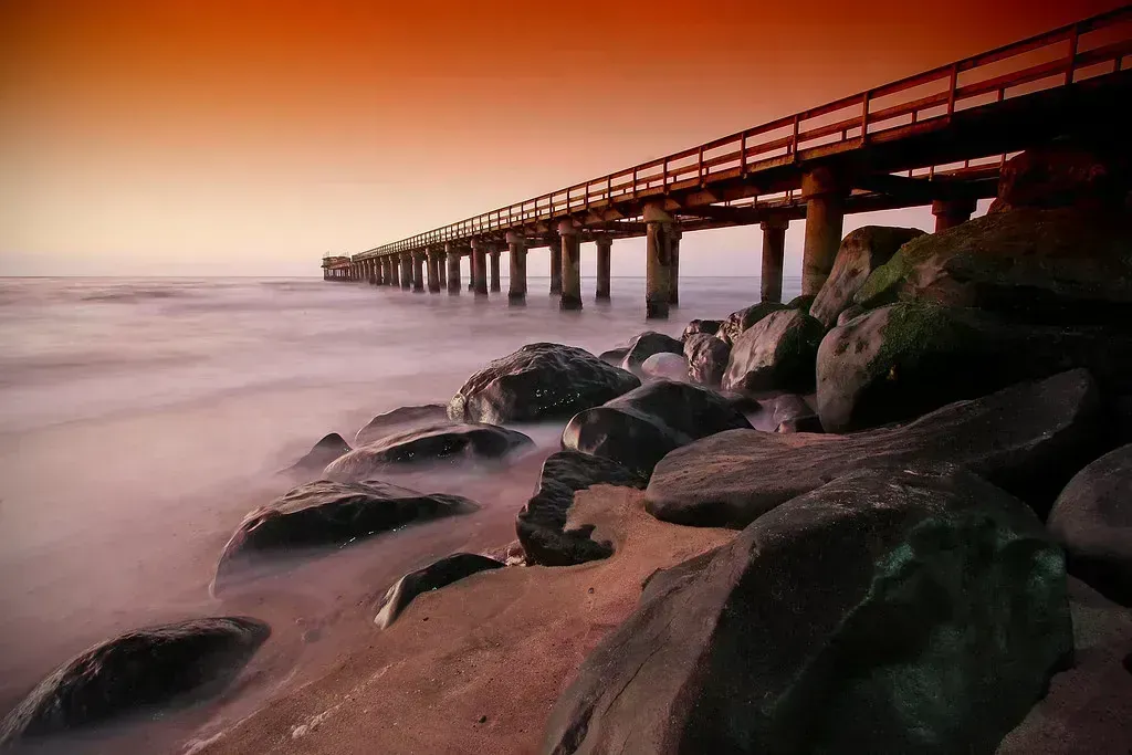 The jetty glows at sunset over a silky Atlantic
